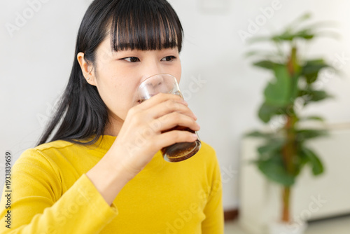 Foto women drinking iced soda from glass at home