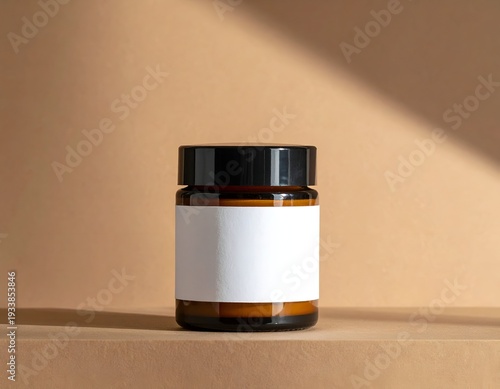 Amber jar with black lid and blank label, illuminated by sunlight on a neutral beige background