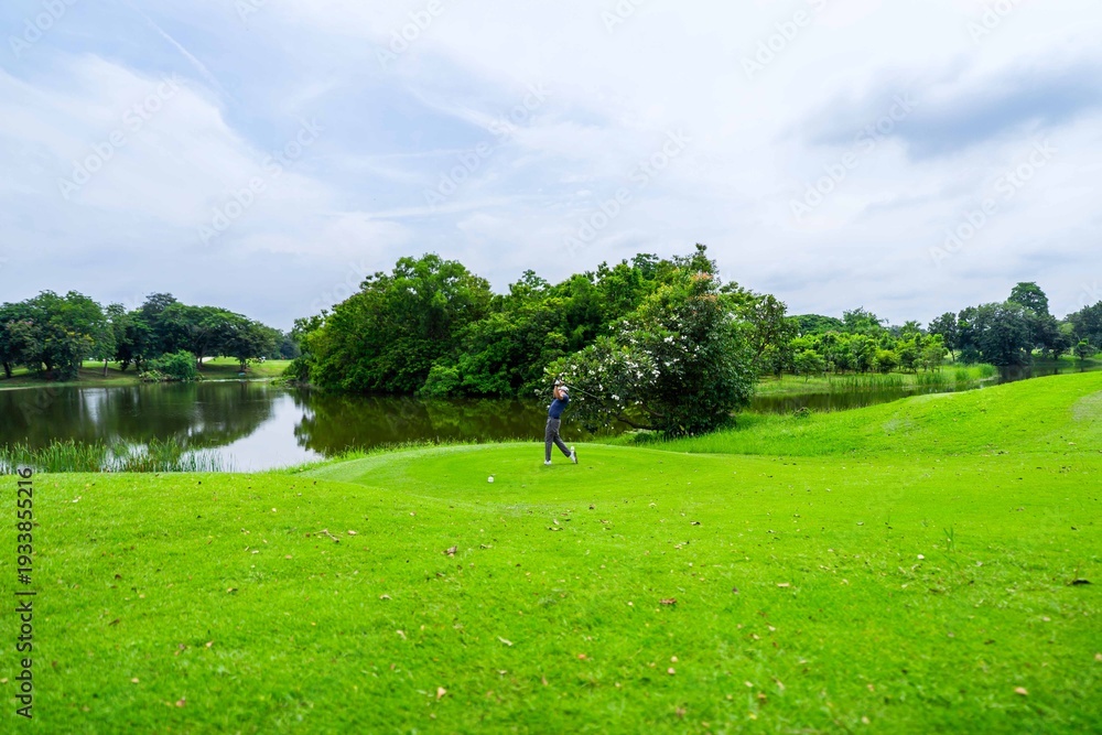 Fototapeta premium Drone view of professional male golfer playing on scenic golf course. 