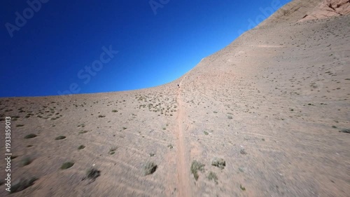 FPV Drone Following Hikers on Remote Desert Path in Central Asia