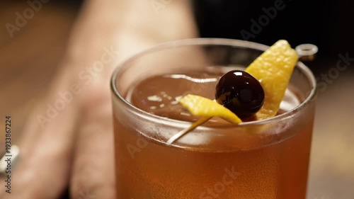 Old fashioned cocktail, serving with cherry and orange peel as garnish. Old fashioned drink.