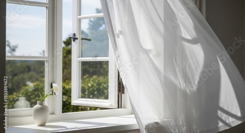 White open window curtains gently billow with fresh air flowing into bright room, illuminating white interior design.