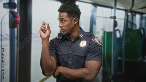 Obraz na plátně Police officer man points finger with crossed arm inside public bus on street; authority vigilance protection