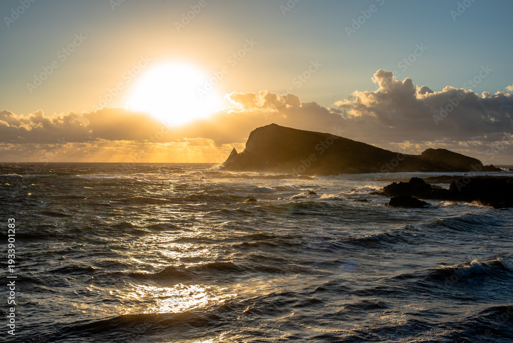 Obraz premium Sunset over rocky island and sea