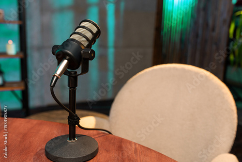 Podcast setup with microphone on table in recording space during evening hours for audio content creation