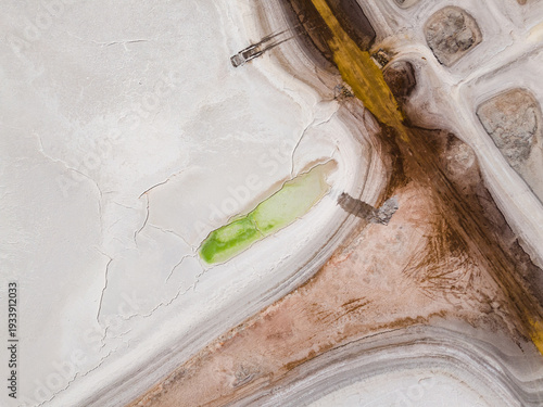 Aerial view of the parched earth, where muted whites meet earthy browns and a splash of vibrant green forms an oasis, Old Chandler, Western Australia, Australia.