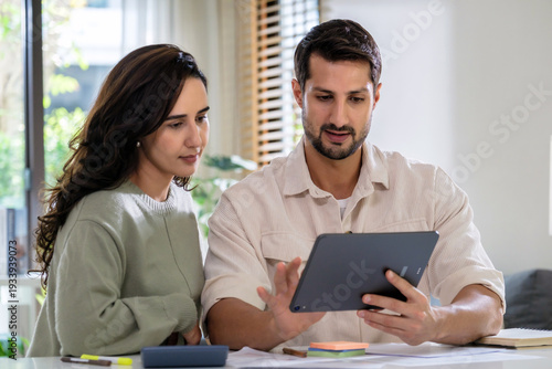 Couple reviewing personal financial calculate tax document while checking expense and payment at home, inspecting bills, budget, insurance, savings, and receipts