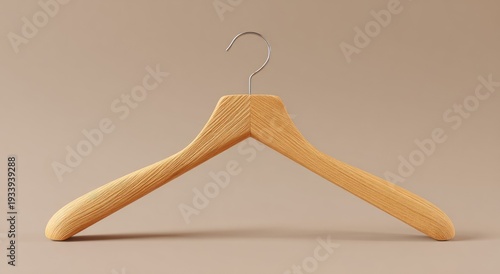 A close-up shot of a wooden clothes hanger, set against a neutral, plain background