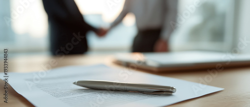Wallpaper Mural  Pen rests on contract while blurred handshake happens behind, symbolizing successful agreement and trust. Torontodigital.ca