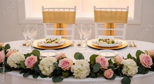 Close up of bridal sweetheart table with pink roses and golden plate settings