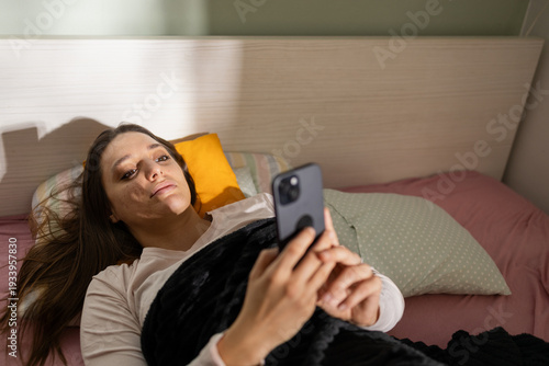 Woman experiencing doomscrolling, lying in bed with phone