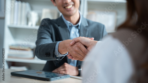 Close up of a real estate agent and client shaking hands for a successful home insurance deal or property mortgage. Concept of house buying, financial agreement, and investment security at office