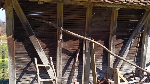 Old wooden barn wall with rustic tools and weathered timber structure in countryside