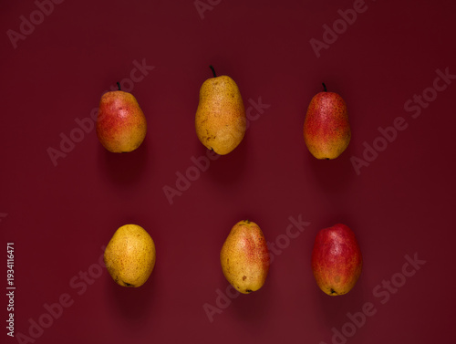 Organic ripe yellow-red pears on a dark background.