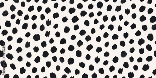 A seamless pattern of irregular black spots on a cream background