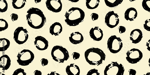 Abstract black brushstrokes form a chaotic organic pattern on a cream background