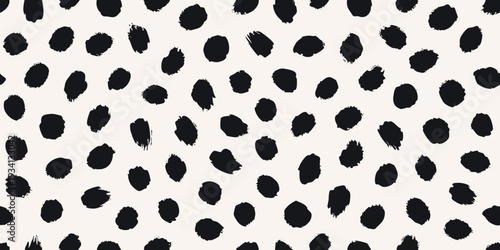 Abstract background featuring irregular black spots on a cream surface