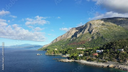 Scenic view of the Maratea coastline with lush green hills meeting the blue waters of the Tyrrhenian Sea under a bright sky. Picturesque Mediterranean landscape ideal for travel and nature concepts.