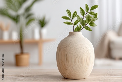 Elegant still life featuring a vase with green foliage against a blurred background, creating a serene and modern aesthetic, perfect for interior design concepts.