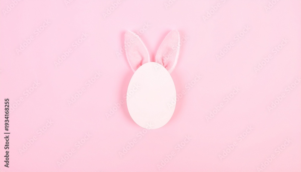 Fototapeta premium White egg with bunny ears on pink background