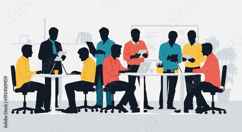 A group of people working together in a modern office space with laptops