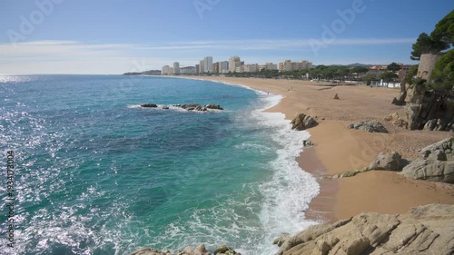 Waves crashing on sandy platja d'aro beach in spain
