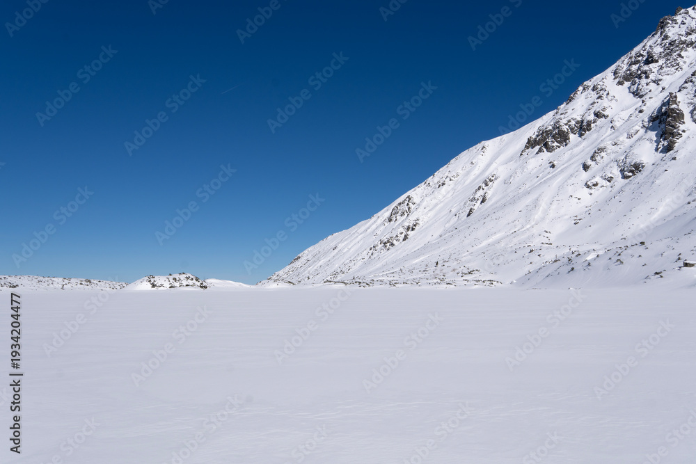 Obraz premium Czarny Staw Gasienicowy lake in Gasienicowa Dolina mountain valley in winter in Tatra Mountains, Poland 