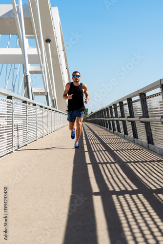 Full-length portrait of male runner during outdoor workout in the city.