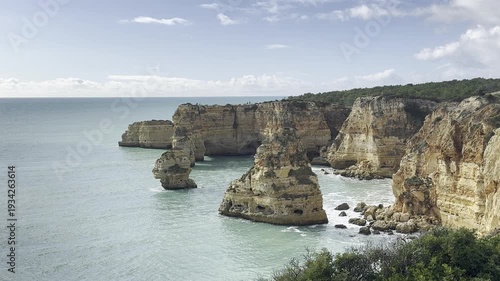 Praia da Marinha, beautiful beach Marinha in Algarve, Portugal. Navy Beach (Praia da Marinha) with flying seagulls over the beach, located on the Atlantic coast in Lagoa Municipality, Algarve.