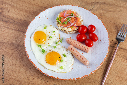 Fried eggs with sausage, cherry tomatoes and buckwheat bread with salmon fish