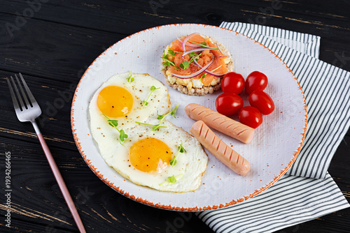 Fried eggs with sausage, cherry tomatoes and buckwheat bread with salmon fish