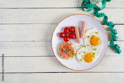 Fried eggs with sausage, cherry tomatoes and buckwheat bread with salmon fish