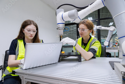 automation machine engineer woman students study and inspection control robot arm machine in robotics engineering academy at university or factory workshop. AI robot technology,
