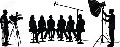 Silhouette of a professional film crew filming a group interview with video camera boom microphone and studio lighting for television broadcast or digital media production.