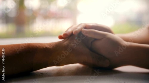daughter talking to her elderly mom while holding hands. Adult woman stroking hands of elder woman. Video of grown-up daughter consoles her old mother.