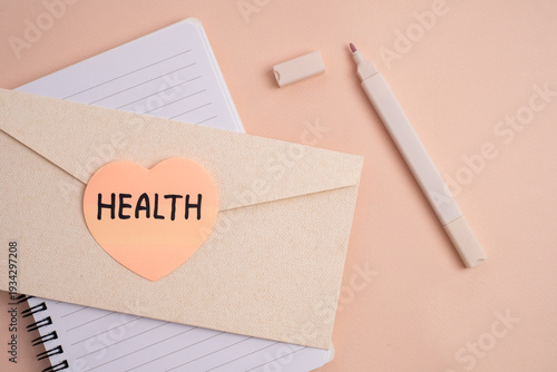 Envelope with health heart-shaped sticker on spiral notebook with marker. Health and wellness concept.