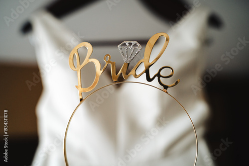 Fotografija Gold bride tiara with diamond icon in front of white wedding dress