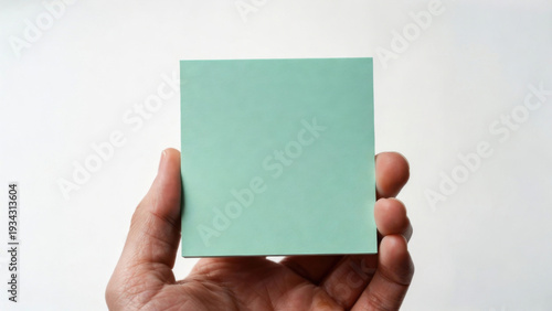 Wallpaper Mural Hand holding a blank light green square sticky note against a white background Torontodigital.ca