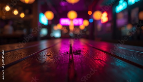 A close-up view of a wooden table in a dimly lit room with colorful neon lights in the background