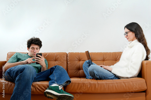 Fotografía Young couple using digital devices ignoring each other