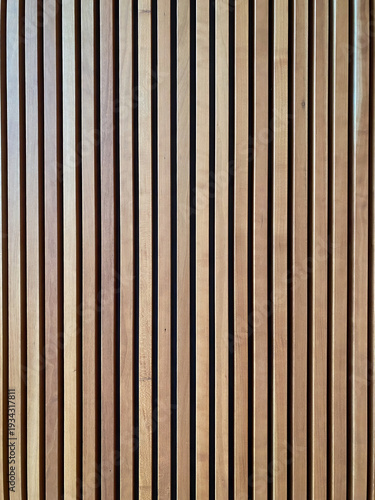 Close up of vertical wooden slats with natural grain and warm tones, creating a clean geometric pattern and minimalist background