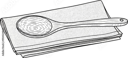 A wooden spoon rests on a folded cloth or napkin