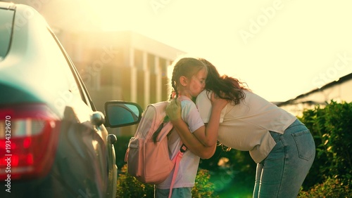 Vászonkép Happy Mother hugs little girl getting ready for primary school lesson in schoolyard