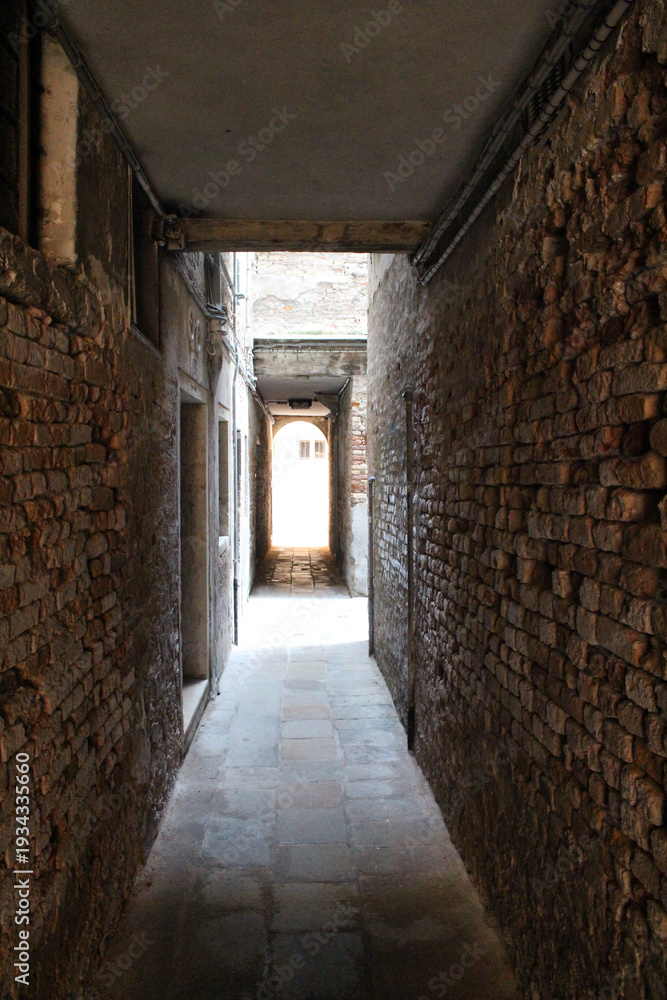 Fototapeta premium Narrow alleyways brick path cobblestone Venezia August 2024