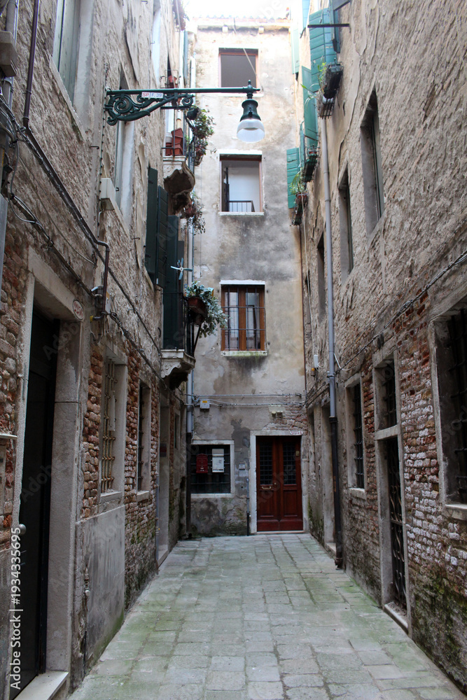 Fototapeta premium Narrow alleyways brick path cobblestone Venezia August 2024