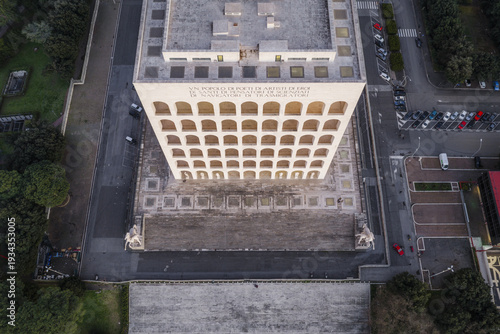 Rome, Italy - 21 February 2026: Aerial view of Palazzo della Civiltà Italiana with its iconic arches, surrounding streets, and parked cars in the EUR district.