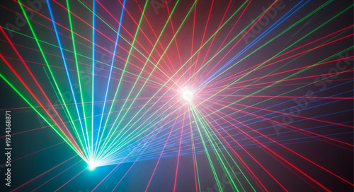 Colorful laser beams crossing in dark space creating abstract patterns.