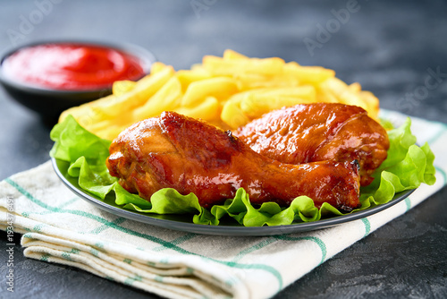 Wallpaper Mural Grilled chicken drumsticks with ketchup and french fry on a black table. Torontodigital.ca