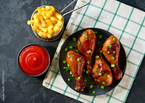 Wallpaper Mural Fried crispy chicken legs with ketchup and french fry on a black table, top view. Torontodigital.ca