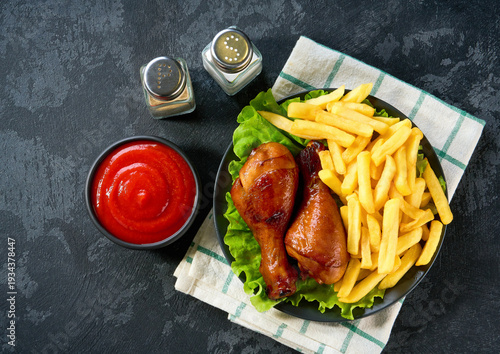 Wallpaper Mural Fried crispy chicken legs with ketchup and french fry on a black table, top view. Torontodigital.ca